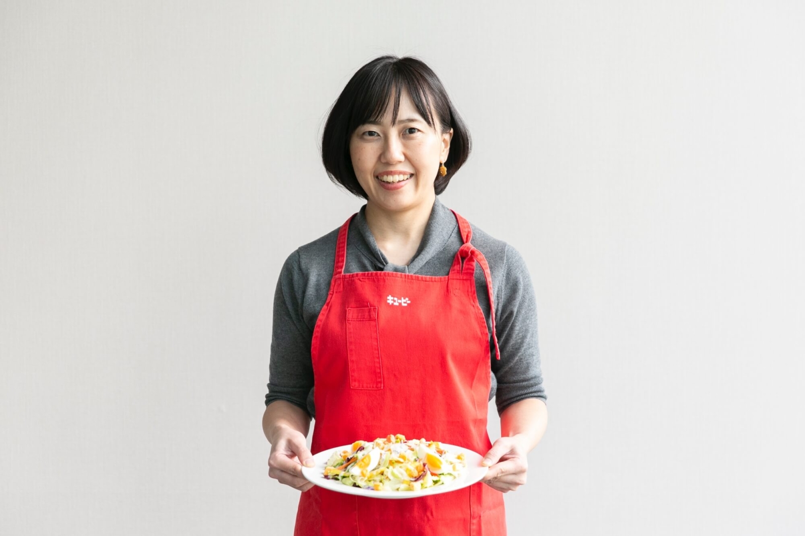 「Qummy 10品目野菜のシーザーサラダ」を持つキユーピー株式会社の小林さん